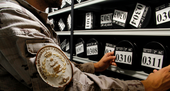 Su origen está ligado a la llegada de la aviación a España y a su Ejército. La fotografía aérea, la fotointerpretación, la fotogrametría y la enseñ...